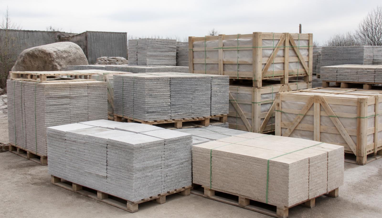 Calibrated Shahabad limestone tiles banded on pallets beside finished timber export crates